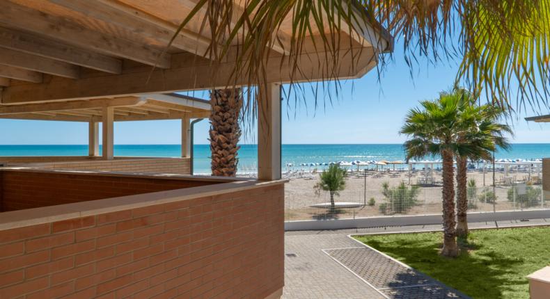 Beach view with palm trees and blue sea.