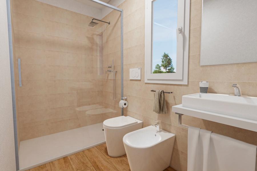 Modern bathroom with shower, sink, and bidet on beige tiles.